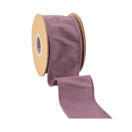 A reel of purple ribbon has a distinctive, softly wrinkled fabric texture and a calm, muted color, suitable for creative projects.