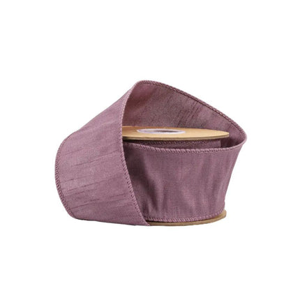 A spool of purple ribbon features a soft, textured fabric with subtle wrinkles, ideal for DIY crafts.