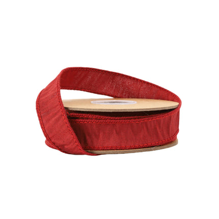 Rich red Christmas ribbon roll, delicate stitching, textured fabric, elegant for holiday crafts.