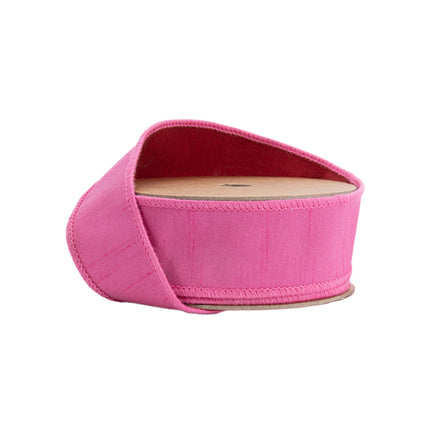 A spool of reversible pink textured ribbon with a red reverse side, ideal for decor, crafting, and gift wrapping projects.