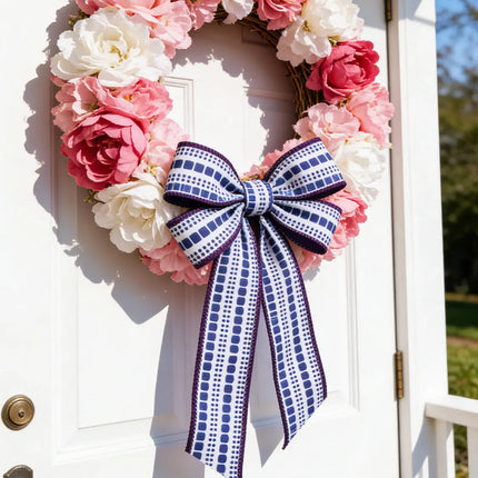 Blue and white geometric wired ribbon bow on a pink and white floral wreath.