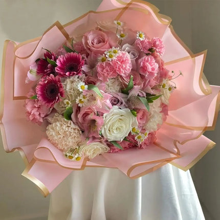 Luxurious mixed pink floral bouquet featuring roses, gerberas, and carnations, wrapped in Wild Rose Matte Floral Sheets with Gold Edge