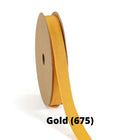 Spool of gold grosgrain ribbon, unrolled to display its textured weave.