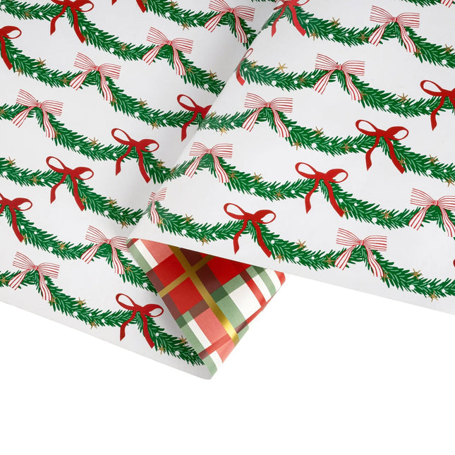 Double-sided festive gift wrap with decorative evergreen bow pattern and shiny holiday tartan