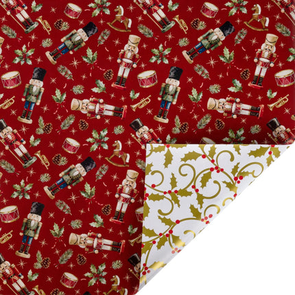 Reversible metallic Christmas wrapping paper with red nutcracker & holly print front and gold holly scroll reverse