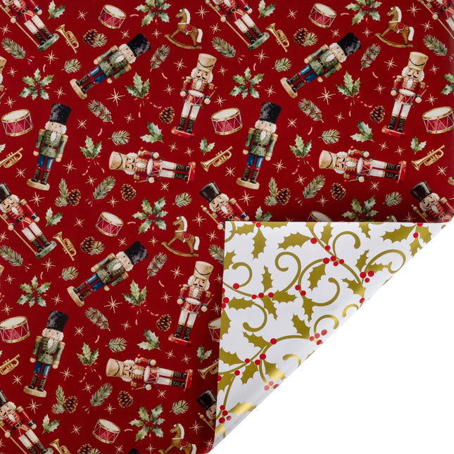 Reversible metallic Christmas wrapping paper with red nutcracker & holly print front and gold holly scroll reverse