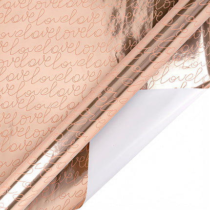 Rose gold metallic wrapping paper with script “love” (white back); gift wrapping.
