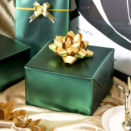 Matte green wrapped gift boxes with gold bows, perfect for holiday, birthday and upscale gift presentation.
