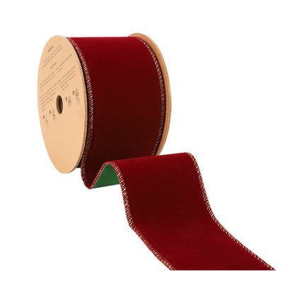 Red velvet ribbon spool, reversible green side, neat stitching, ideal for Christmas decorations.
