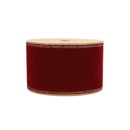 Red velvet ribbon roll, sleek design with detailed stitching, perfect for holiday gifting & decor.
