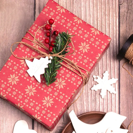 Festive Christmas gift wrapped in red kraft paper with beige snowflake patterns