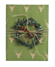 Green and beige reindeer kraft wrapped gift with twine bells